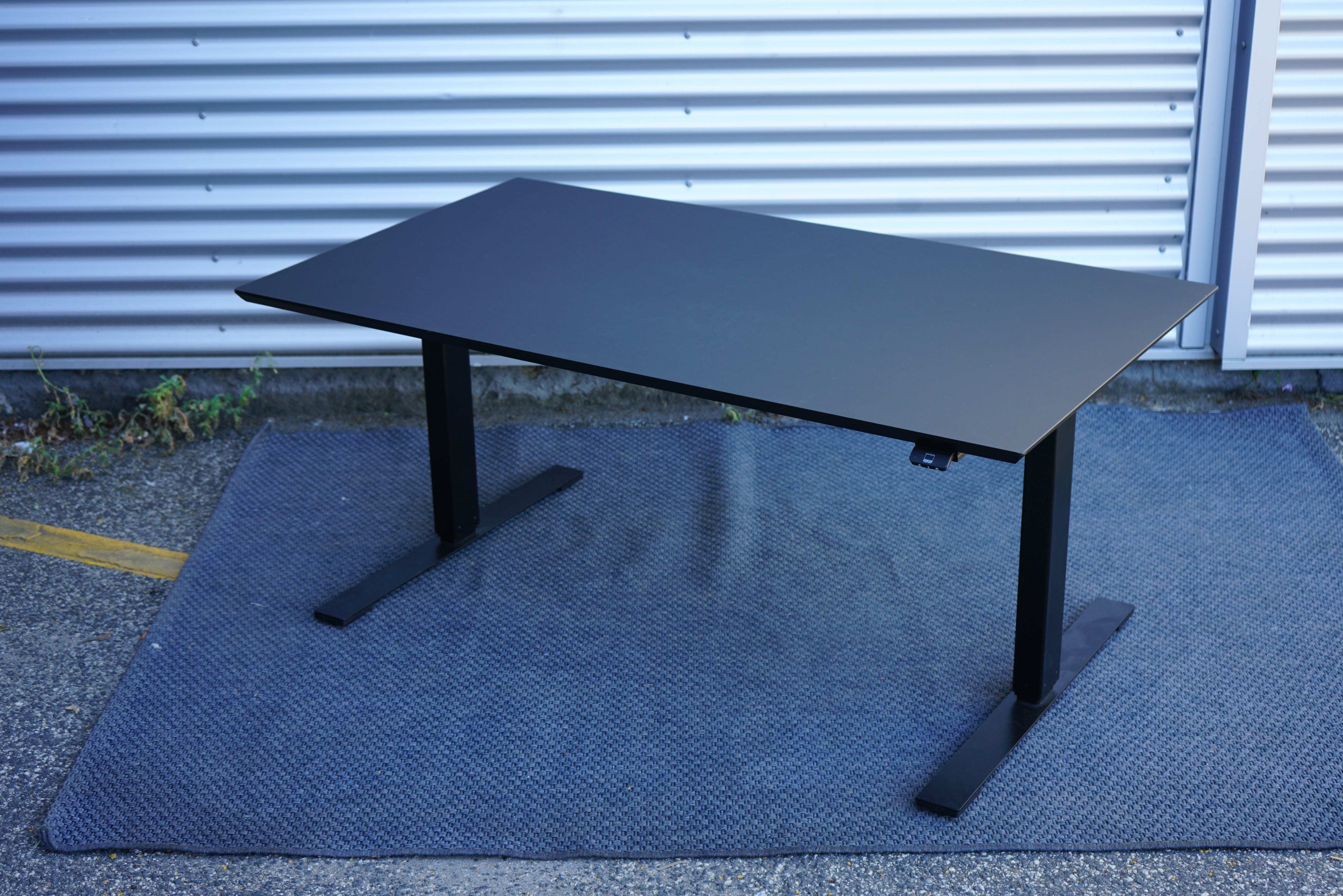 Dencon hæve-sænkebord 140x80 i sort linoleum med sort stel set bagfra